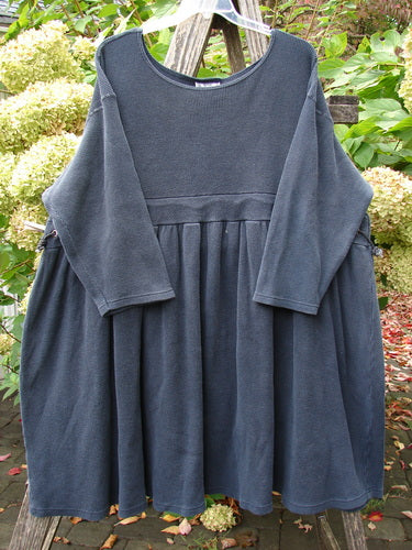 1992 Thermal Circus Dress Unpainted Black Size 2: Dark gray, long-sleeved dress with a gathered skirt, wide rounded neckline, and empire waist cord, gracefully drapes on a clear hanger outdoors.