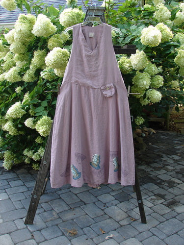 1999 Patio Jumper Fancy Bake Bowls Heliotrope Size 0 displayed on a clothes rack, showcasing its sleeveless design, gathered rear waist seam, and a tiny shell button pocket.