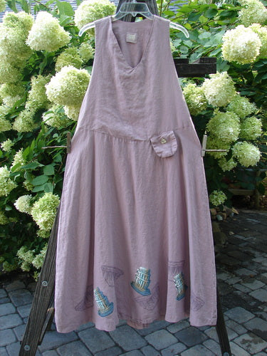 1999 Patio Jumper Fancy Bake Bowls Heliotrope Size 0 hanging on a clothesline, showcasing its sleeveless design, deep arm openings, exterior pocket with shell button, and long, flowing A-line shape.