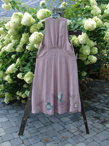 1999 Patio Jumper Fancy Bake Bowls Heliotrope Size 0 displayed on a clothes rack, showcasing its sleeveless upper with deeper arm openings, exterior pocket with shell button, and long, flowy A-line shape.