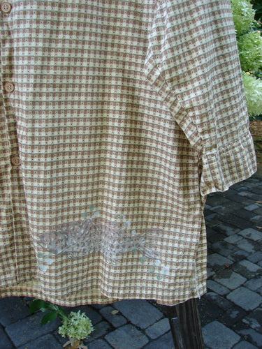 Close-up of the 1996 Woven Tourist Top Fish Border White Pine Gingham OSFA, showcasing wooden buttons, vented sides, lower sleeves with buttoned cuffs, and a stand-up collar.