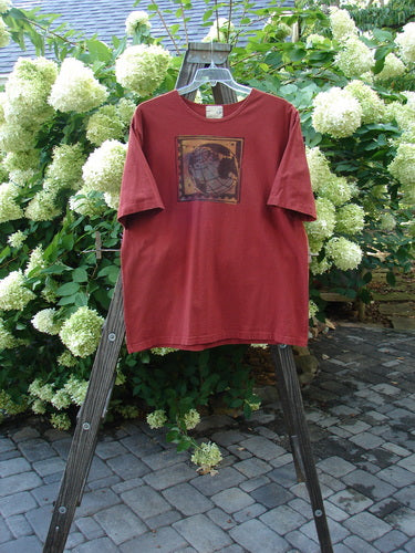1998 Men's Artist Choice Short Sleeved Tee Earth Brick Size 2 on a wooden stand, featuring a classic earth-themed print and a softly thicker ribbed neckline, in perfect condition.