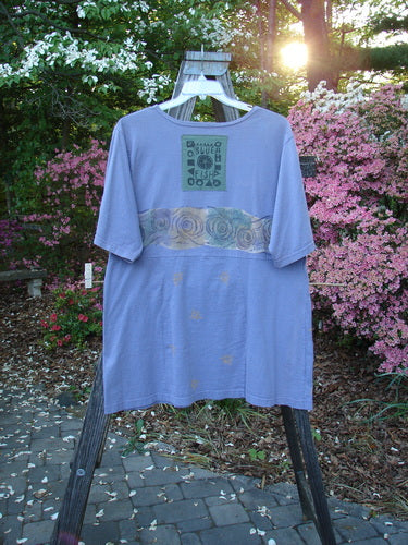The 1993 3 Square Dress Wind Band Periwinkle OSFA displayed on a hanger, featuring a rounded neckline, six sectional panels, and a signature Blue Fish patch on the back.