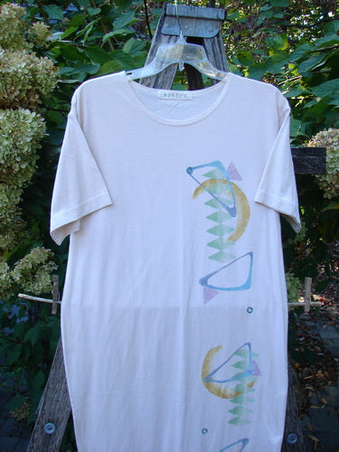 1996 Long Tea Dress Half Moon Birch Bark Size 0 displayed elegantly over a wooden ladder, showcasing its long, straight shape, seamless design, and pastel abstract print amidst a garden setting.