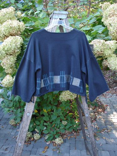 1999 Interlock Side Tie Jacket Fall Grid Black Size 2: A short, boxy-cut top with patchwork hem details, wide belled sleeves, and drawcord sides, draped on a rustic wooden ladder.