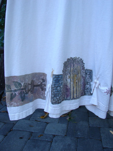 1994 Loop Dress Magic Garden Tea Dye Smaller OSFA features hand-painted motifs of a branch and stone archway on ivory fabric, showcasing Blue Fish's unique, graceful design with flared hem and dual cord lacings.