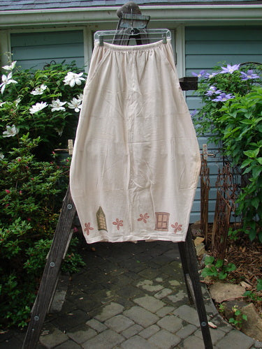1993 Resort Bell Skirt Window Teadye Size 2 on a clothesline, featuring unique horizontal and vertical seams, front pockets, a pegged shape, rear kick vent, and window theme paint.