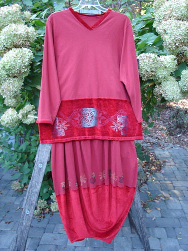 The 1996 Velvet Arrowhead Sofia Duo Pomegranate Size 1 2 showcases a deep rose-red tunic with embroidered accents and a matching skirt, highlighting vintage elegance against a floral backdrop.