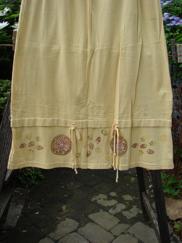 1999 Basket Skirt Fruit Slice Buttercup Size 1: Medium weight organic cotton skirt with fruit slice design, full elastic waistband, deep side pockets, and flared A-line cut, accented with buttercup rippies.
