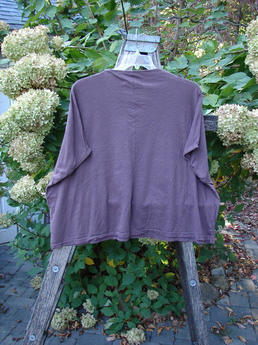 Barclay NWT Cotton Slub Cricket Cap Sleeve Tee Travel By Sun Fig OSFA displayed on a wooden ladder in a garden. The lightweight, seamless top showcases cool cap sleeves and a rounded hemline.