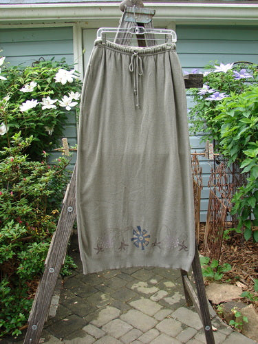 1996 Cotton Cashmere Skirt Pinwheel Green Shade on Shade Size 2, displayed on a wooden ladder, featuring a drawstring waistband with two deep side pockets and a slightly tapered ribbed hem.
