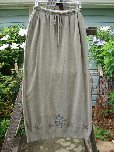 1996 Cotton Cashmere Skirt Pinwheel Green Shade on Shade Size 2, hanging on a ladder, showcasing its full length and tapered hem, with a visible drawcord waistband and deep side pockets.