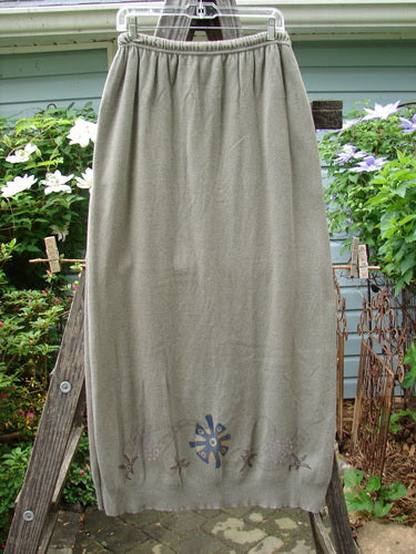 1996 Cotton Cashmere Skirt Pinwheel Green Shade on Shade Size 2 displayed draped over a wooden ladder, highlighting the full elastic waistband, side pockets, and tapered ribbed hem in a cozy, textured fabric.
