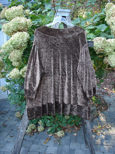 1997 Velvet Surya Top Subtle Celtic Border Mandorla OSFA draped on a wooden ladder, showcasing its plush texture, wide neckline, flared hem, and distinctive painted Celtic border against a lush garden backdrop.