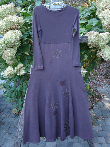 1998 Rib Top Dress Snowflake Morado Size 0 features a long-sleeved, flared dress with starburst appliqués, showcasing a ribbed upper and empire waist, hanging against a natural backdrop.