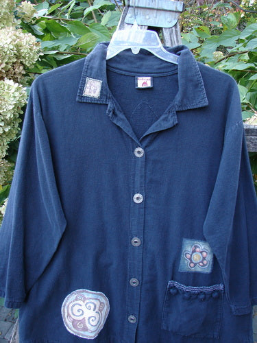 Barclay Patched Flannel PJ Pom Pom Top Pinwheel Black Size 0, featuring appliqué patches and contrasting buttons, hangs outdoors, highlighting its pinwheel patch, pom-pom accented pocket, and rounded hemline.