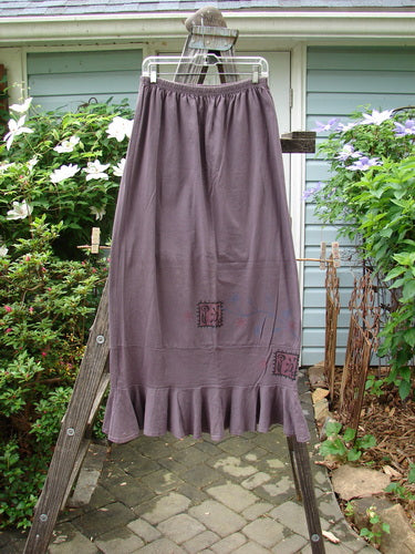 1996 Spring Laughter Skirt Stitch Vine Violet Field Size 2, displayed on a ladder, showcasing its full elastic waistband and detailed vine stitching with a slimming drape and an 8-inch lower band flounce.