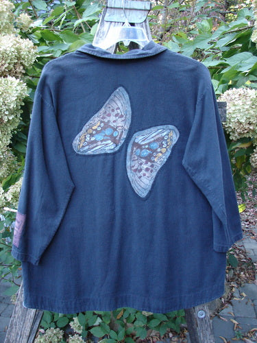 Barclay Patched Flannel PJ Pom Pom Top Pinwheel Black Size 0 features butterfly-wing appliqués on a dark jacket, displayed on a wooden easel amidst garden foliage, embodying Bluefishfinder's vintage, expressive style.