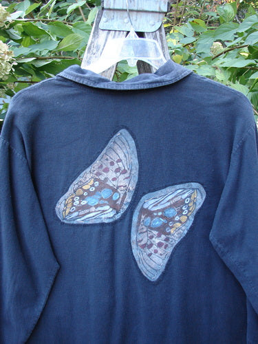 Barclay Patched Flannel PJ Pom Pom Top Pinwheel Black Size 0: A lightweight black top with butterfly wing designs, featuring pinwheel patches, front buttons, an oversized pocket with pom poms, and a rounded hemline.