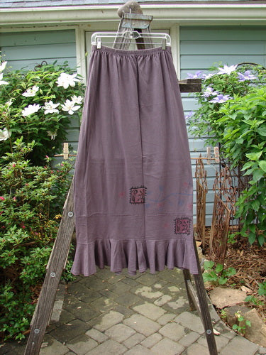 1996 Spring Laughter Skirt Stitch Vine Violet Field Size 2 displayed on a wooden ladder, highlighting its detailed vine stitching and full elastic waistband.