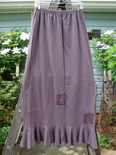 1996 Spring Laughter Skirt Stitch Vine Violet Field Size 2, displayed draped on a wooden ladder, showcasing detailed stitch vine patterns and a full elastic waistband.