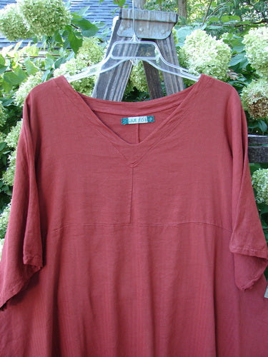 Barclay Linen Viscose Vented Urchin Dress Unpainted Brick Stripe Size 2 displayed on a wooden swinger, showcasing its three-quarter length sleeves and downward curved empire waist seam.