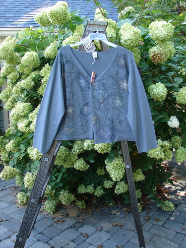 Barclay NWT Layering Cardigan Shrug Rain Flower Blue Dusk Size 2 displayed on a wooden stand, featuring an open front, trailing rain flower paint, and a varying hemline.