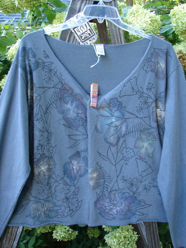 Barclay NWT Layering Cardigan Shrug Rain Flower Blue Dusk Size 2, featuring a blue shirt with a flower design, longer sleeves, open front, varying hemline, and trailing rain flower theme paint.