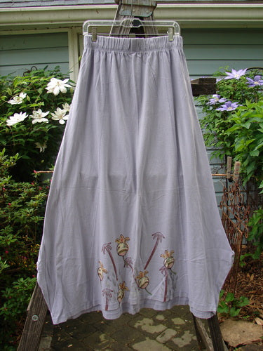 1998 Botanicals Gillyflower Skirt Bud Wisteria Size 2 on a rack, showcasing a detailed floral design, full elastic waistband, sectional seams, and a unique widening-narrowing hem.