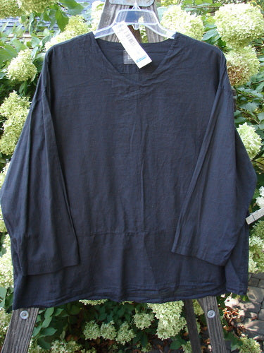 2000 Batiste Overshirt Top Unpainted Black Size 2 displayed on a wooden hanger, showcasing its boxy silhouette, drop shoulders, and softly rounded V-neckline, highlighting the breezy handkerchief linen texture.