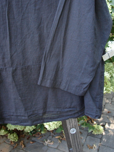 2000 Batiste Overshirt Top Unpainted Black Size 2, featuring a drop waist seam with flounce and softly rounded V neckline, shown in a close-up emphasizing its breezy, lightweight handkerchief linen fabric.