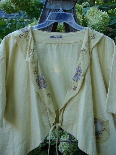 Barclay Linen Batiste Rippie Tie Jacket Shrug Florals Quiet Sunshine Size 2 showing a deep V neckline, flutter collar, painted floral design, longer front tie, and seamless back.