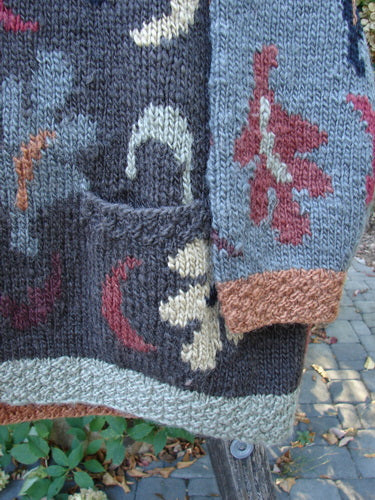 Tara Handknits Star Button Pocket Cardigan Leaf & Moon Brights OSFA features a vibrant hand-knit design with abstract motifs, visible pocket, and a ribbed cuff, embodying artisanal craftsmanship from Northern California and Nepal.