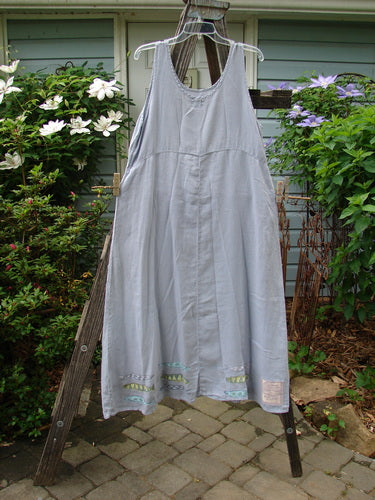 1999 Handkerchief Linen Sunbeam Dress Fish Water Size 1 displayed on a clothes rack, featuring a full-length sweeping skirt, an empire waist seam, and sectional panels.