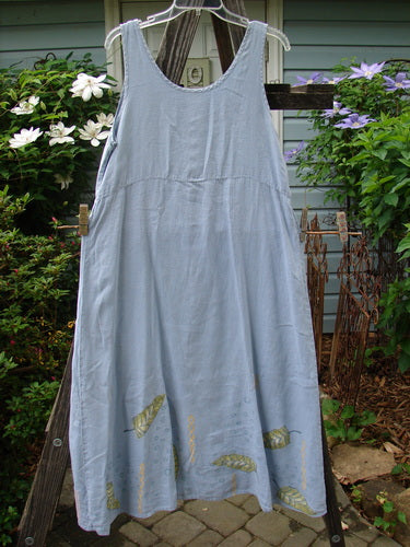 1999 Handkerchief Linen Sunbeam Dress Leaf Water Size 1 displayed on a clothesline, showcasing its full-length sweeping skirt, empire waist seam, and sectional panels with a sweet leaf theme.