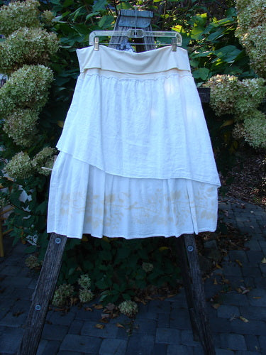 Barclay NWT Linen Fold Over Generosity Skirt Leaf Field Fresh White Size 2, draped on a hanger, features a tiered, gauzy design with a painted leaf motif, showcasing an organic cotton and batiste blend.