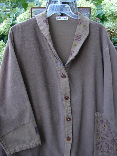 Barclay Patched Flannel Frolic Jacket Vine Garden Rock Size 2 displayed on a hanger, showcasing long sleeves, a unique patched and painted neckline, oversized front pocket, and distinctive button details.