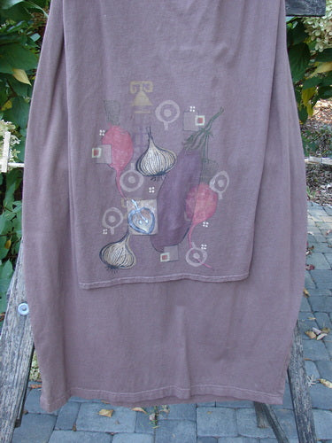 Barclay Button Panel Skirt Vegetable Sepia Size 2 draped over a chair, featuring stylized vegetable prints, including garlic, eggplants, and red peppers, with geometric motifs, emphasizing its unique harvest theme design.