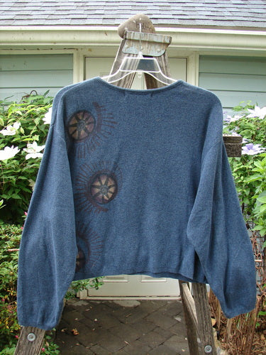1997 Cotton Cashmere Crop Pullover Star Wheel Marled Blueprint Size 3 displayed on a hanger, showcasing its long sleeves, boxy shape, drop shoulders, ribbed hemline, and rolled ribbed neckline with detailed star wheel design.