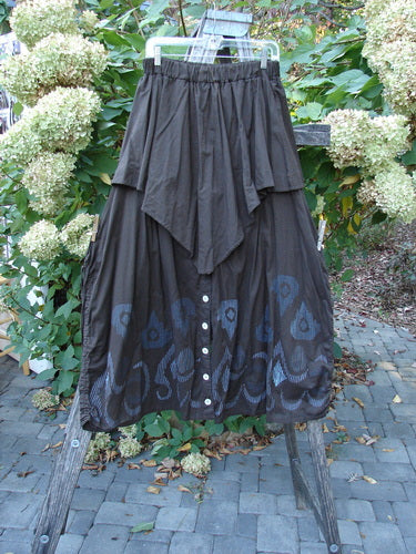 Barclay Batiste Split Button Pant Skirt in Celtic Mocha Size 0, hangs outdoors, showcasing its layered triangular overskirt, button details, and abstract hem print, embodying vintage Blue Fish individuality.