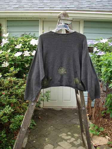 1997 Cotton Cashmere Crop Pullover Column Marled Granite Size 3 displayed on a wooden ladder, showcasing its slightly shorter boxy shape, drop shoulders, thinly ribbed hemline, and rolled ribbed neckline.