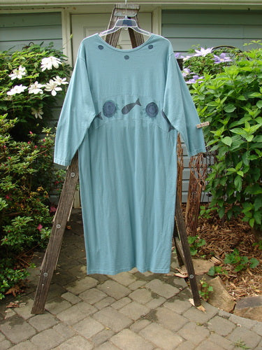 1995 Empire Dress Moon Fish Venus Size 2 featuring a downward curved upper waist panel, rolled neckline, and fish motif, displayed on a rack.