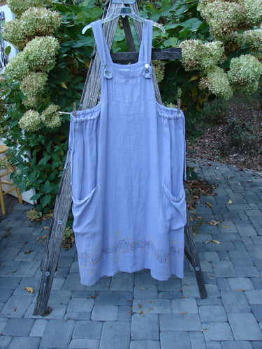 2000 Hemp Summercloth Hi Way Overall Jumper Star Border Twilight Size 2 hangs from a wooden trellis, showcasing its adjustable straps, large side pockets, and unique star border design against blooming hydrangeas.
