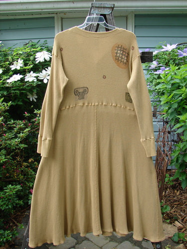 1995 Thermal Soliloquy Dress Architectural Burnished Gold Size 2 displayed on a stand, featuring tiny front snaps, ribbed accents, drop waistline, and a sweeping hemline, highlighting its intricate abstract design.