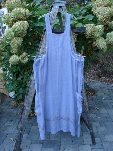 2000 Hemp Summercloth Hi Way Overall Jumper in Twilight, featuring wide straps, side pockets, and embroidered hem, hangs on a wooden ladder outdoors, embodying Bluefishfinder.com's vintage, expressive style.