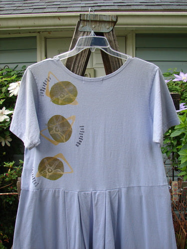 1997 Lawn Dress Side Geo Freesia Size 1 displayed on a hanger, featuring tailored pleats, drop waistline, and signature Blue Fish patch, made from organic cotton.
