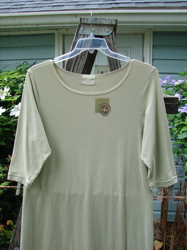 2001 Tide Dress Jax Kelp Size 1 displayed on a plastic hanger with a wooden stand, showcasing its three-quarter length sleeves, slightly flared lower, and straighter, longer shape.