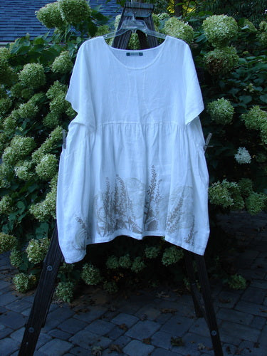 Barclay Linen Studio Pullover Dress Breeze Fern White Size 2 displayed on a rack, featuring a flouncy lower skirt, gathered waistline, wide hem sweep, and unique figure 8 front bodice seams.