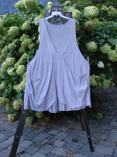 Barclay Gauze Farmer Jen Sleeveless Tunic Unpainted Lilac Size 2 displayed on a rack, showcasing its deep V neckline, spacious arm openings, and widening lower A-line shape with stacked lower pockets.