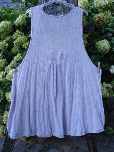 Barclay Gauze Farmer Jen Sleeveless Tunic Unpainted Lilac Size 2 hanging on a clothesline, showcasing a deep V neckline, wide arm openings, and a stacked lower pocket ensemble.